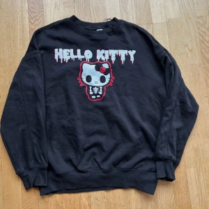 Oversized Hello Kitty tröja 🖤 - Säljer en cool svart tröja från H&M med ett Hello Kitty-tryck i vitt och rött. Materialet är mjukt i 50/50 polyester & bomull! 🖤köpt för 299 kr, endast använd 3 gånger & sen tvättad. 