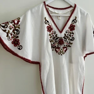 Vintage långklänning med broderi - Otroligt vacker långklänning med broderi. Perfekt till midsommar! Passar flera storlekar tack vare bandet man kan knyta i ryggen. Väl omhändertagen och i fint skick. Djur- och rökfritt hem.