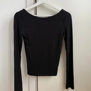 Svart långärmad topp - Snygg svart långärmad topp med öppen rygg. Tröjan kommer från Gina Tricot’s soft touch kollektion. Aldrig använd! 