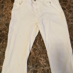 Vita byxor från butiken flash - Snygga vita byxor från flash  i en klassisk stil. Perfekta för en stilren look. Byxorna har en knapp och dragkedja framtill. De är lite kortare än vanliga jeans de är till lite strax under knäna , köpte de för 300kr men jag kommer sälja de för mycket billigare . Helt oanvända 