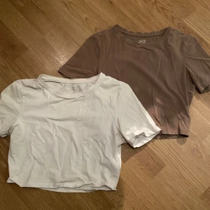 Två t-shirts från 157. Den vita tröjan S. Den bruna tröjan XS. - Säljer två t-shirts från 157 i storlek XS. En är vit och den andra är beige. Båda är tillverkade av 95% bomull och 5% elastan, vilket ger en skön och stretchig passform. Perfekta basplagg för vardagsbruk.
