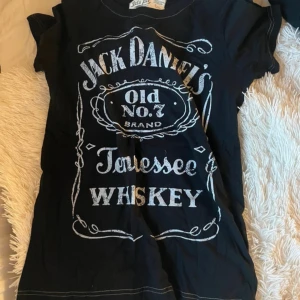 Jack Daniels T-shirt - En Jack Daniels T-shirt som aldrig är använd, köptes för 2 år sedan på ett marknadsstånd för 400kr. Lite stor i storleken.