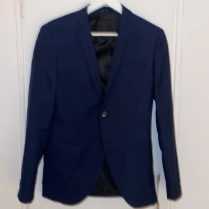 Mörkblå kostym - Snygg mörkblå kostym med kavaj och byxor. Kavajen har två knappar och en stilren design. Perfekt för formella tillfällen. För mer information är det bara att skriva. Passar perfekt att köpa en nu innan alla kostymer blir dyra till sommaren🔥🔥🔥🔥🔥