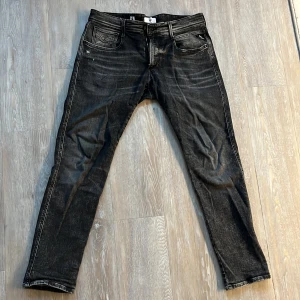 Svarta/Gråa jeans från Replay - Snygga svarta jeans från Replay med en klassisk femficksdesign. De har en diskret tvättad look och är tillverkade i slitstarkt denim. Perfekta för en stilren vardagslook. Pris kan diskuteras.