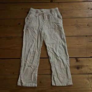 Beige linnebyxor från Grunt - Säljer ett par beige byxor från Grunt i storlek M. Byxorna har en rak passform och är tillverkade i ett lätt material, perfekt för en avslappnad stil. De har en midwaist design och är enkla att matcha med olika toppar. Lite korta i längden, tvättade i för hög grad! Säljer pga-passar ej längre. Inte använda mer än 5 ggr. Skriv om du har mer frågor!