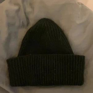 Svart stickad mössa - Snygg och enkel svart stickad mössa med ribbad design. Helt ny och oanvänd.