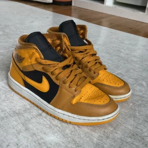 Nike Air Jordans 1 i gult och svart - Säljer ett par snygga Nike Air Jordans i gult och svart. Skorna är i mycket bra skick ( liten crease på högra skon) och har en cool design med snörning och den klassiska Air Jordan-loggan på sidan. Perfekta för både vardag och fest! 🏀✨ pris kan diskuteras 