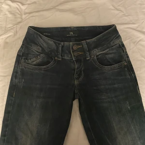Mörkblå jeans från LTB - Säljer ett par mörkblå jeans från LTB i bra skick. De har en snygg tvättad look och är lågmidjade med två knappar fram. Klassiska femficksdesignen med snygga detaljer på bakfickorna. Perfekta för vardagsbruk eller en avslappnad utekväll. Skriv för fler bilder💗