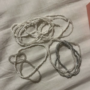 Pärlhalsband i vitt och silver - Säljer flera pärlarmband i vitt och silver. 