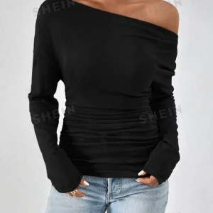 Svart offshoulder topp från SHEIN - Snygg svart offshoulder topp från SHEIN i ett stretchigt material. Perfekt för en kväll ute eller en avslappnad dag. Den har långa ärmar och en tight passform som framhäver figuren. Enkel att matcha med jeans eller kjol för en stilren look. Aldrig använd