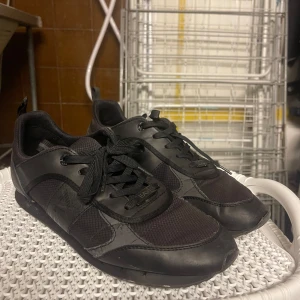 EA7 Emporio Armani Svart - Detta är en helt svart model av EA7 skorna jag har jätte många av men av helt svart har jag faktiskt bara ett om jag har rätt. Detta är ett par cleana billiga och fräscha skor som passar till det mesta för ett lågt pris. Storleken är en 43a som nästan alla andra jag har dock har jag fler om ni vill höra av er och kolla vilka färger och storlekar jag har så är det okej, jag är jätte snabb på att svara så det är bara att skriva.