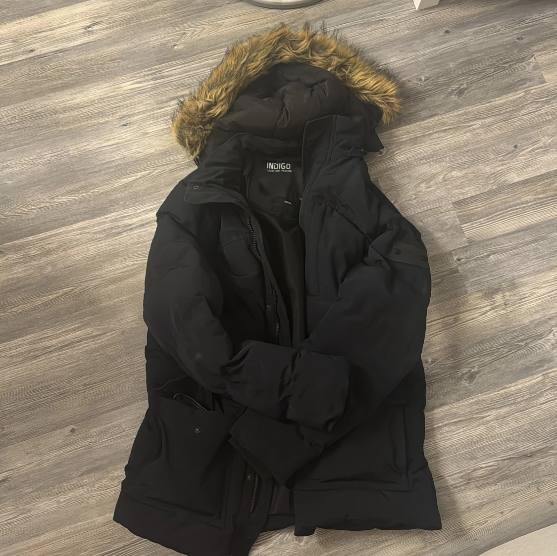 Svart vinterjacka med pälsdetalj från Indigo