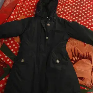Säljer en svart parkajacka i damstorlek XS från GB. Jackan har en praktisk huva och stängs med både dragkedja och knappar. Perfekt för höst och vinter med sin långa ärm och stilrena design. Den är i bra skick och redo för nya äventyr!