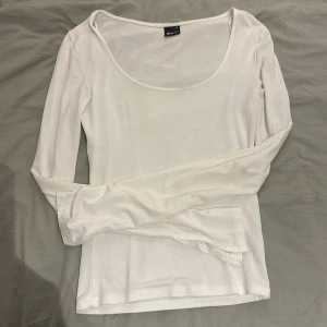 Vit långärmad, U-ringad topp från Gina Tricot - Säljer en enkel vit långärmad topp från Gina Tricot i storlek XS. Perfekt basplagg, med en bekväm passform. Helt fri från fläckar. Toppen är använd få gånger och därför mycket bra skick. Hör av dig om du funderar över något! 