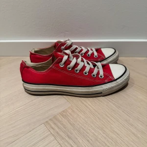 Röda sneakers från Converse - Säljer ett par klassiska röda Converse All Star sneakers med vita snören och gummisula. Perfekta för en avslappnad stil.