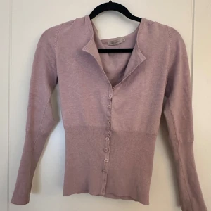 Ljusrosa kofta från Saint Tropez - Säljer en ljusrosa kofta från Saint Tropez. Den har långa ärmar och knappar framtill. Perfekt för en stilren look.