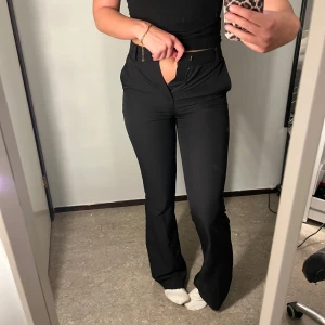 Svarta kostymbyxor - Snygga svarta kostymbyxor med hög midja och bootcut-stil. Säljer pågrund av att dom blivit för små i midjan, jätte snygga till både fest och vardag😍