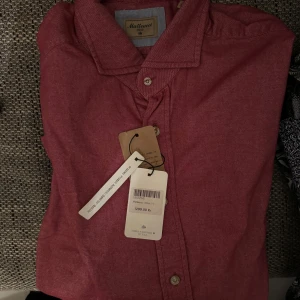 Helt ny Röd skjorta från Matteucci - Snygg röd skjorta från Matteucci i storlek 42 Skjortan har en klassisk krage och knappar framtill. Perfekt för en stilren look.