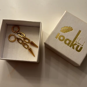 Guldörhängen! - Säljer ett par snygga guldörhängen. De har en cool design med kedjelänkar och en spetsig detalj längst ner. Perfekta för att ge din outfit en edgy touch! ALDRIG ANVÄNT⚠️