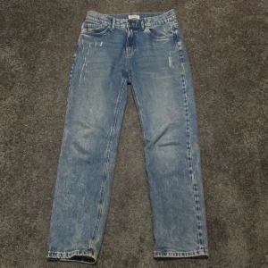 Blå jeans i bra skick - Säljer ett par klassiska blå jeans i bra skick. De har en straight passform och är tillverkade i slitstarkt denim. Perfekta för vardagsbruk och kan matchas med nästan vad som helst. De har en snygg tvättad look med lite slitningar för en cool stil. (Accepterar endast Swish pga lurendrejerier) (Checka även in andra kläder på min profil och köp tillsammans för ett rabatterat pris) 