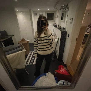 Randig stickad tröja - Säljer en mysig stickad tröja med svartvita ränder. Tröjan har långa ärmar och ribbade muddar vid ärmslut och nederkant. Köpt på Gina för 400