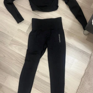 Mörkgrått träningsset från complete - Säljer ett mörkgrått träningsset från complete i storlek S. Setet består av en långärmad croppad topp och matchande tights, båda i ett stretchigt och bekvämt material. Perfekt för gymmet eller yoga, skulle säga att settet passar mer Xs