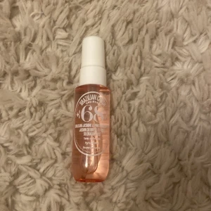 Brazilian Crush Cheirosa 68 - En doftspray från Sol de Janeiro med en fräsch och blommig doft av brasiliansk jasmin och rosa drakfrukt. Flaskan är genomskinlig med en rosa ton och har en vit spraykork. Perfekt för att fräscha upp under dagen.