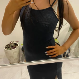 Blå ribbad klänning - Snygg svart ribbad klänning med smala axelband och en liten slits på sidan. Perfekt för en stilren look.