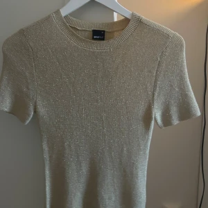 Glittrig tröja  - Snygg glittrig guldig tröja från Gina Tricot i storlek XS