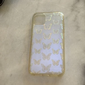 Transparent mobilskal med fjärilsmönster till IPhone 11 - Snyggt transparent mobilskal med holografiska fjärilar som skiftar i regnbågens färger. Perfekt för att ge din telefon ett unikt och stilrent utseende samtidigt som den skyddas mot repor och stötar. 