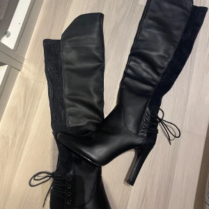 Boots  - Svarta boots med snörning, vilket gör de ganska unika ✨ Cirka 10 cm klack, se bild. Anledningen till att jag säljer de är för de (Passar ej breda fötter eller vader). Testat endast en gång. Finns små defekter på bootsen då de stått orörda i garderoben i några år.
