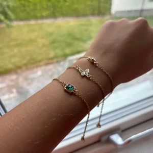 Guldarmband med fjäril och grön sten - Tre eleganta guldarmband, ett med en vacker fjärilsdetalj, den  andra med en grön steninfattning och tredje med en diamant sten.Perfekta för att lägga till en subtil touch av färg och elegans till din stil.Alla för 20kr!