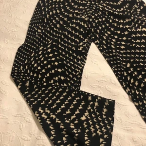 Mönstrade byxor från Bitte Kai Rand - Snygga byxor från det danska designermärket Bitte Kai Rand med ett  mönster i svart och beige. Byxorna har en hög midja och en loose passform. Generös i storleken. Köpte själv på Vinted med den var tyvärr för stor för mig som har storlek 36-38. Den är snarare storlek 38-40. Bilderna lånade från den ursprungliga annonsen.