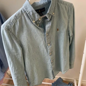 Ralph Lauren skjorta - Ralph lauren skjorta i storlek 16år som motsvarar ungefär xs eller 164 färgen är ljusblå lite uttvättad skick 10/10. Bara att skriva vid frågor samt intresse.