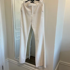 Vita kostymbyxor från Zara Woman - Säljer mina kostymbyxor från Zara Woman med hög midja och bootcut passform. Byxorna är i storlek S, har sytt in dem i midjan men går lätt att sprätta upp
