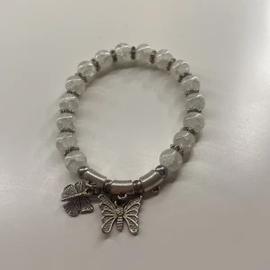 Pärlarmband med fjärilsberlocker - Charmigt armband med fjärilar på. Väldigt söt och passar till allt. En fjäril saknas men fortfarande väldigt fin 