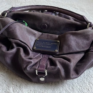 marc jacobs hobo bag - supersnygg och trendig marc jacobs väska i vinröd/plommon färg med silvriga detaljer. väldigt rymlig så perfekt till jobb eller skola!