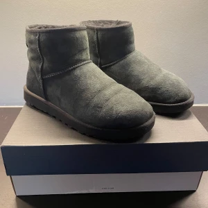Svarta UGG skor - Säljer ett par svarta UGG skor i mocka. De har en mjuk och varm insida, perfekt för kyliga dagar. Jag har endast använt dem fåtal gånger, alltså är dem i ett väldigt bra skick! Det finns box till dem, nypris: 2400kr. Även nyinpregnerade! Bara att höra av dig för funderingar. Priset är ej hugget i sten!