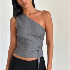 Grå oneshoulder topp - Snygg grå oneshoulder topp med knytband i midjan från motel rocks. Fick den i julklapp men eftersom den va en aning för stor för mig säljer jag den. Ny med prislapp på! Kostar €43 nypris vilket motsvarar 492 kr🥰