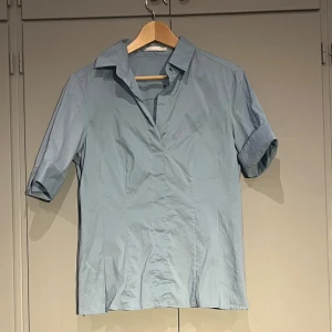 Ljusblå kortärmad blus från Boss - Helt oanvänd ljusblå blus från märket Boss. Skick 10/10. DE 42, UK 14, US 10