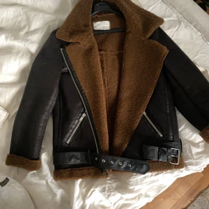 Zara bikerjacka, aviator, shearlingjacka  - Bikerjacka / shearlingjacka / aviator från Zara med brunt varmt teddyfoder. Sparsamt använt ett fåtal gånger. Storleken är Large men skulle säga att den passar S-L beroende på hur man vill att den ska sitta!  Nypris var 1399sek.