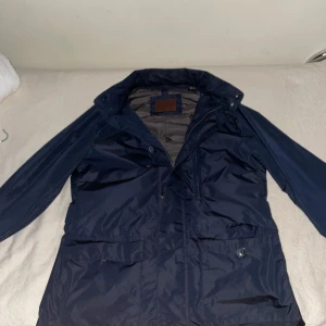 Mörkblå jacka från Massimo Dutti - Snygg mörkblå jacka från Massimo Dutti med knappar och dragkedja. Perfekt för höst och vår. Jackan har långa ärmar och en stilren design. Har använt den 2 gånger men den är för stor för mig