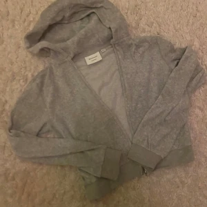 Juicy couture tröja - Snygg grå hoodie från juicy couture med dragkedja framtill och huva. Långärmad med ribbade muddar vid ärmslut och nederkant. Sparsamt använd så i bra skick!