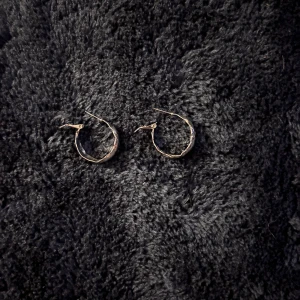 Silverfärgade örhängen i ringform - Snygga silverfärgade örhängen i ringform med en vriden design. Perfekta för att ge en elegant touch till din outfit. Lätta att bära och passar till många olika stilar.