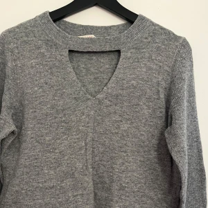 Grå stickad tröja från Esprit - Säljer en stilren grå stickad tröja från Esprit. Tröjan har en v-ringning vid bröstet och armarna är lite utsvängda. Osäker på storlek men runt M. Köpt för 699 kr