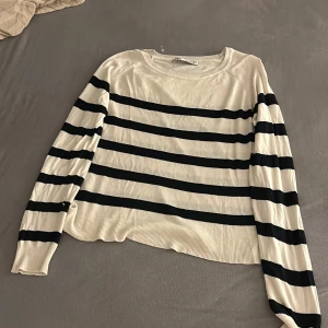 Randig tröja från Zara - Säljer en stilren randig tröja från Zara i svart och vitt. Tröjan har långa ärmar och en rund halsringning. Perfekt för en avslappnad look. Säljer för de kommer inte till användning lägre.