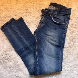 Blå slim jeans - Tiger of sweden jeans med snygg tvätt. Jeansen är i modellen slim och är sparsamt använda. storlek 31/32