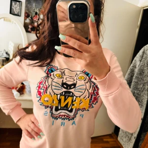 Rosa sweatshirt från Kenzo med tigertryck - Säljer en supercool rosa sweatshirt från Kenzo med ett färgglatt tigertryck på framsidan. Tröjan är i storlek M och är perfekt för både vardag och fest. Den är i nyskick och väldigt bekväm att ha på sig. Passar perfekt till höst och vår. 🐯💖