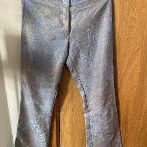 Supercoola low waist blå/guldiga jeans - Coola guld/blåjeans som tyvärr är för små och har en liten defekt på en av bälteshylsorna.