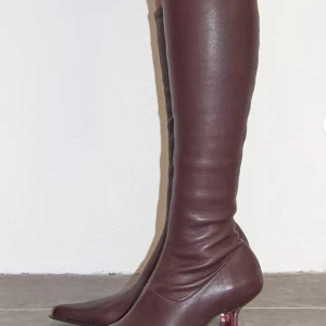 Bruna stövletter med klack - Säljer ett par snygga burgundy stövletter i skinn från Miista. De har en spetsig tå och en elegant klack som ger en stilren look. Perfekta för höst och vinter, och funkar lika bra till vardags som till fest. storlek 37, normal i storleken.